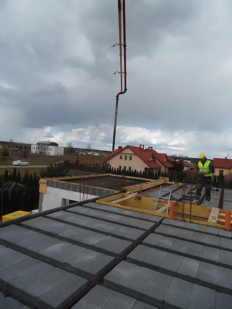 Budowa domu jednorodzinnego – pompa do betonu ustawiona przy domu przed wylaniem stropu