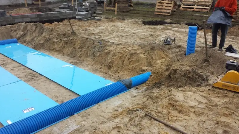 Budowa domu jednorodzinnego – układanie kolejnych pasów izolacji termicznej płyty fundamentowej
