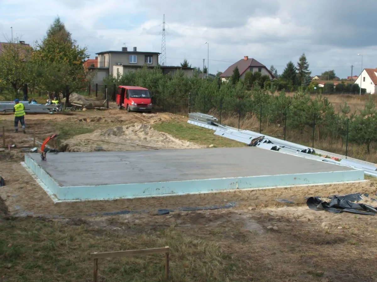 Budowa domu jednorodzinnego – widok na plac budowy z rozpoczętą płytą fundamentową