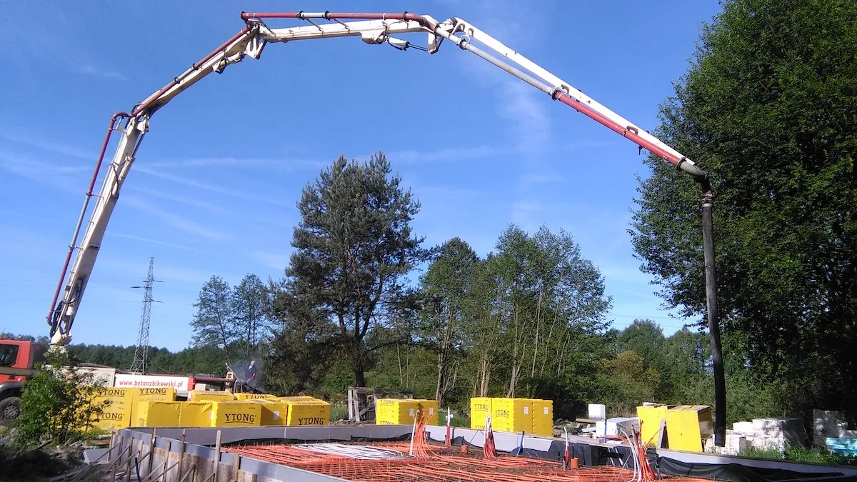 Budowa domu jednorodzinnego – betonowanie płyty fundamentowej w otoczeniu drzew