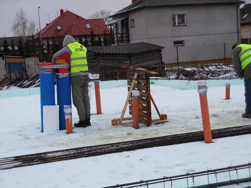 Budowa domu jednorodzinnego – montaż elementów instalacji na ocieplonej płycie fundamentowej zimą