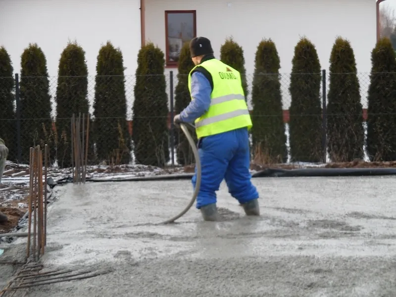 Budowa domu jednorodzinnego – wyrównywanie świeżo wylanego betonu na płycie fundamentowej